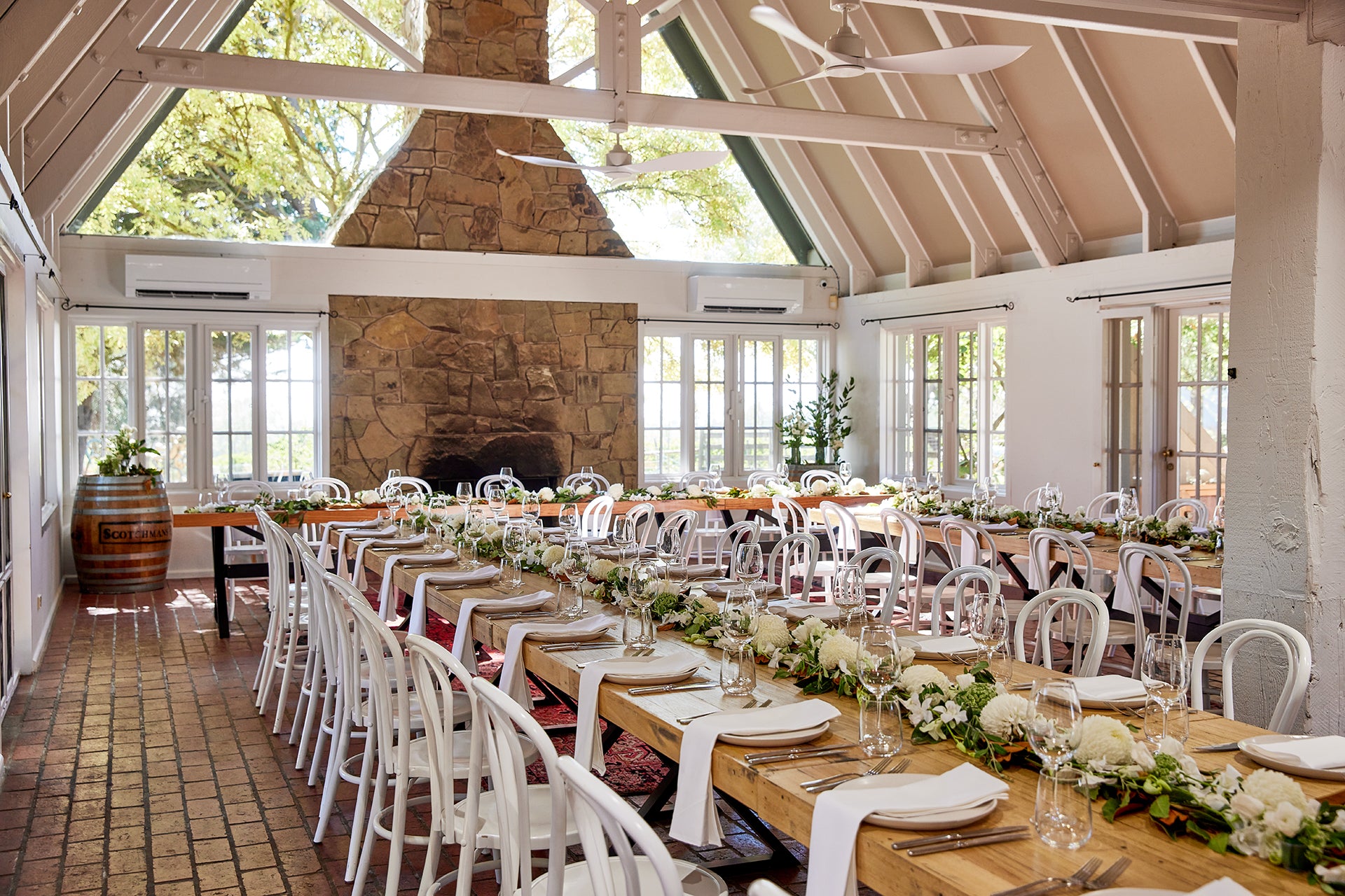 Long dining tables set for a wedding in The Residence at Scotchmans Hill, Geelong, with fireplace and romantic French provincial interiors.