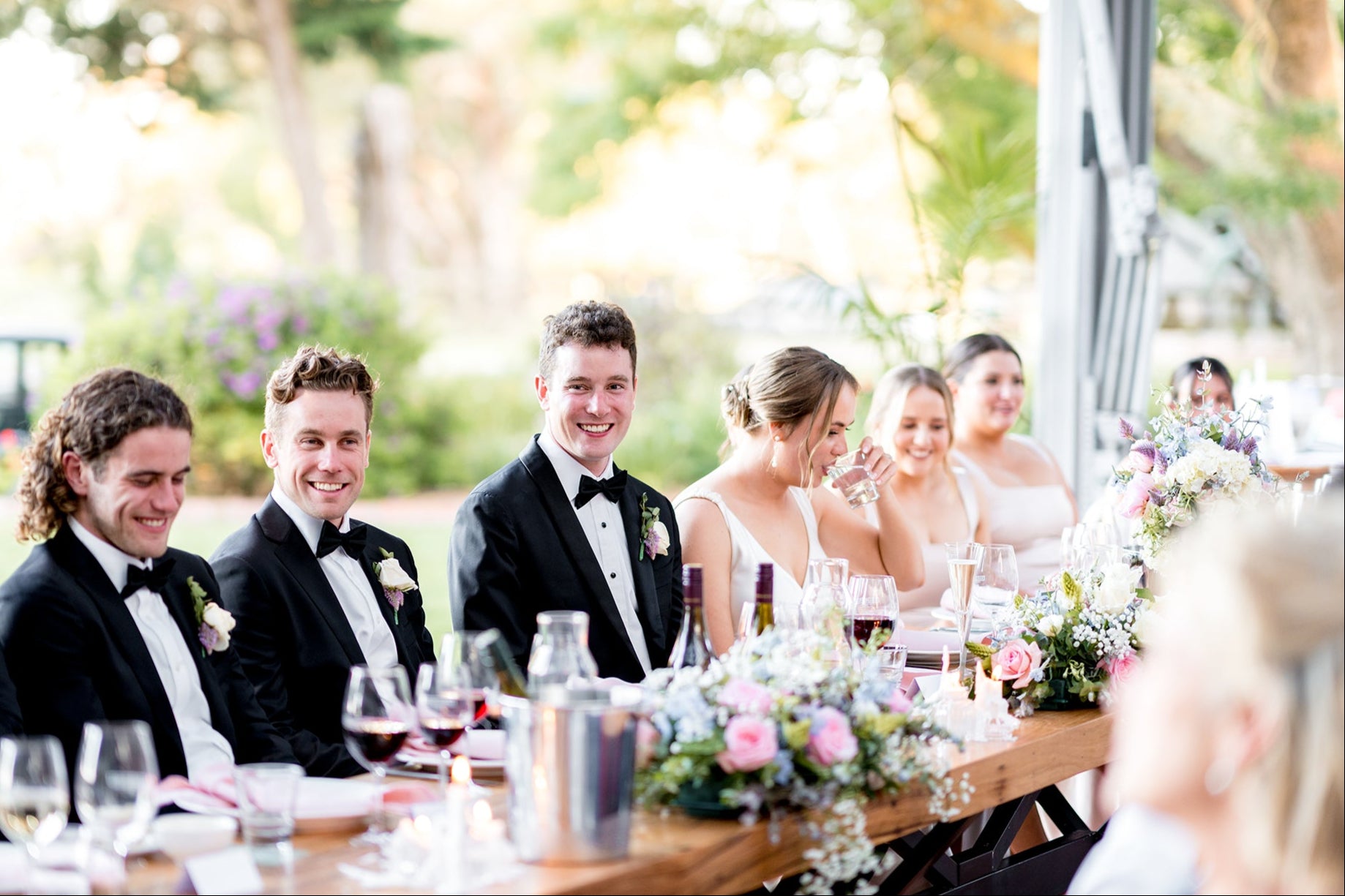 Bridal party seated at the head table during a wedding reception at Scotchmans Hill restaurant.