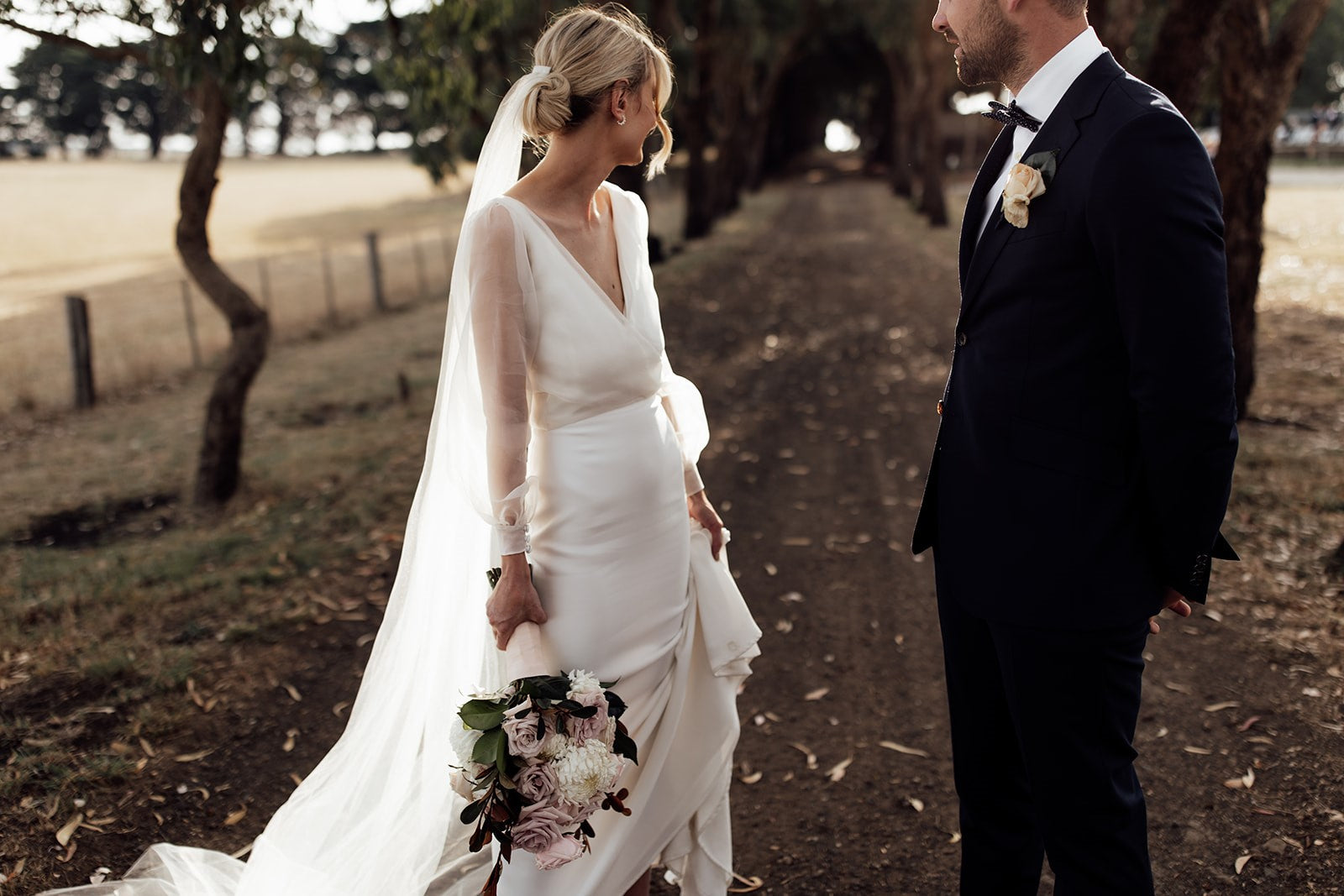 Bride and groom sharing a moment on the tree-lined driveway at Scotchmans Hill, Bellarine Peninsula winery wedding venue near Geelong.